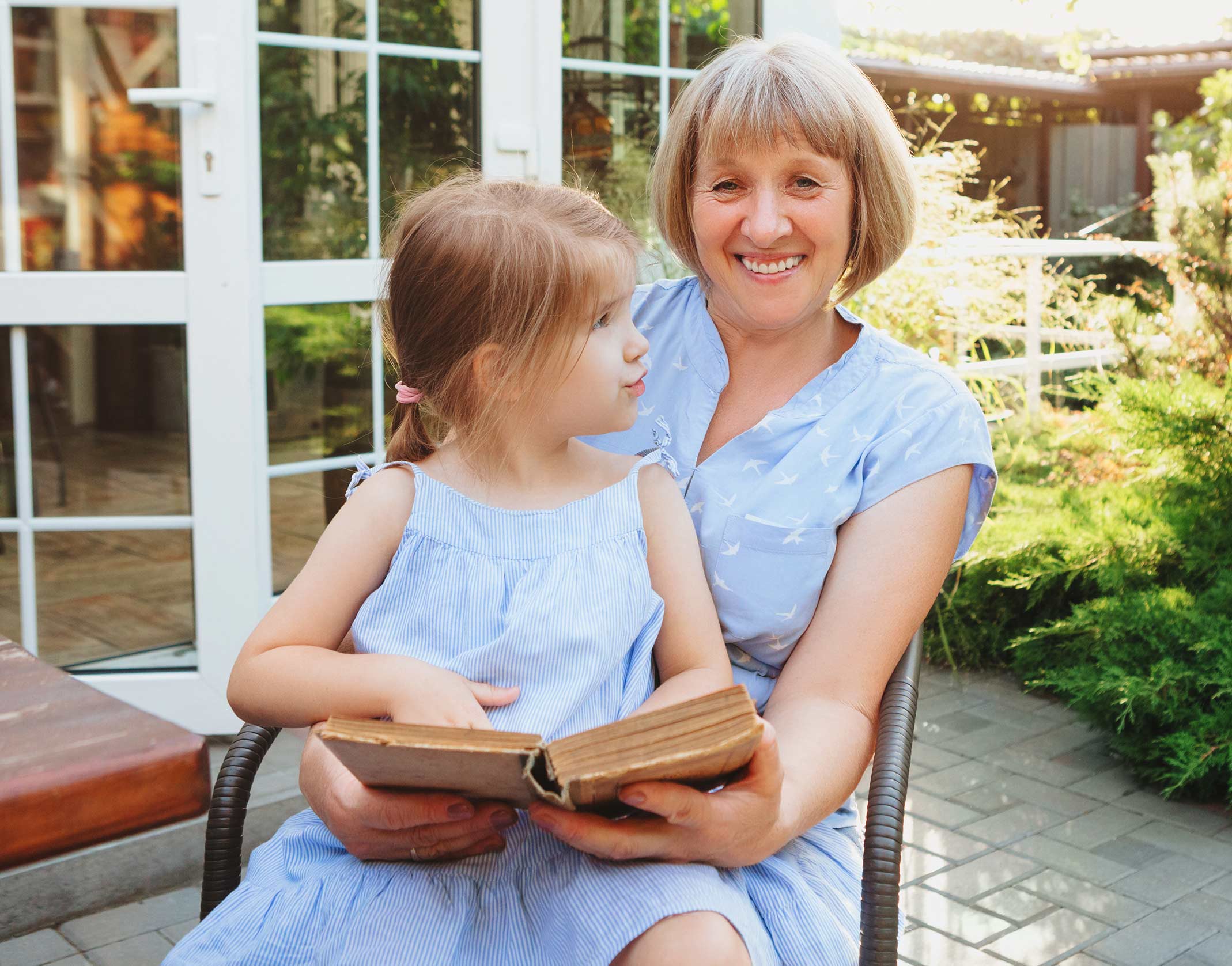 Life After Cataract Surgery | The Eye Care Center Adult enjoying reading with grandchild after fast cataract surgery recovery showing restored clear vision