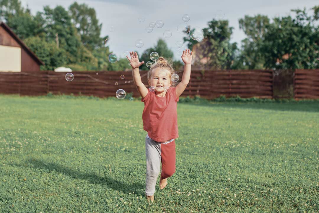 Outdoor Time Myopia Protection Children | The Eye Care Center Child playing outdoors in bright sunlight demonstrating the protective effect of outdoor time on myopia in children