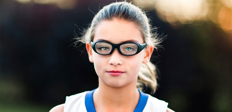 Child athlete wearing safety goggles while playing basketball to prevent eye injuries
